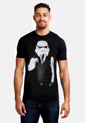 Black short-sleeve t-shirt featuring a Stormtrooper graphic in a tuxedo. The design is printed in white on the front, creating a stark contrast.