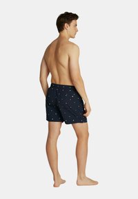 Costumi da bagno blu navy con elastico in vita, caratterizzati da motivi quadrati colorati. Tessuto leggero e a asciugatura rapida. Taglio classico con vestibilità comoda.