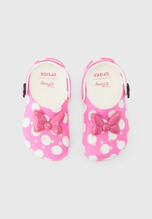 Pink Crocs with white polka dots and glittery pink bows, featuring Disney branding inside each shoe.