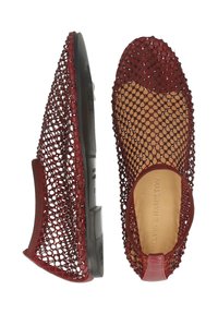 Czerwone buty slip-on z otwartym splotem, z czarnymi podeszwami i brązowymi wkładkami, przedstawione z boku i z góry.