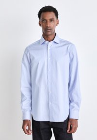 Hellblauen gestreiften Button-up-Hemd mit langen Ärmeln, klassischem Kragen und weißen Knöpfen. Der Stoff wirkt glatt und leicht.