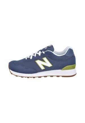 Zapatilla New Balance azul y verde con cordones blancos, mediasuela blanca y suela exterior marrón, vista desde el lado interior.