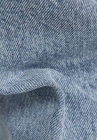 Ljusblå denimtyg med en fin, strukturerad väv. Har subtila vita strimmor och en mjuk fall, perfekt för avslappnad klädsel.