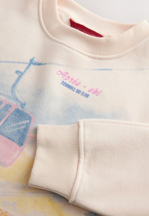 Lichtroze sweatshirt met een graphic van een pastelkleurige skipendeltaxi, gestructureerde geribde manchetten en geborduurde tekst "Aprés-ski Downhill Ski Club".
