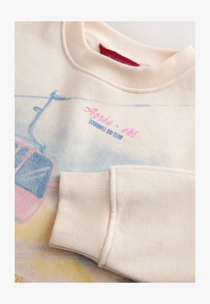 Lichtroze sweatshirt met een graphic van een pastelkleurige skipendeltaxi, gestructureerde geribde manchetten en geborduurde tekst "Aprés-ski Downhill Ski Club".