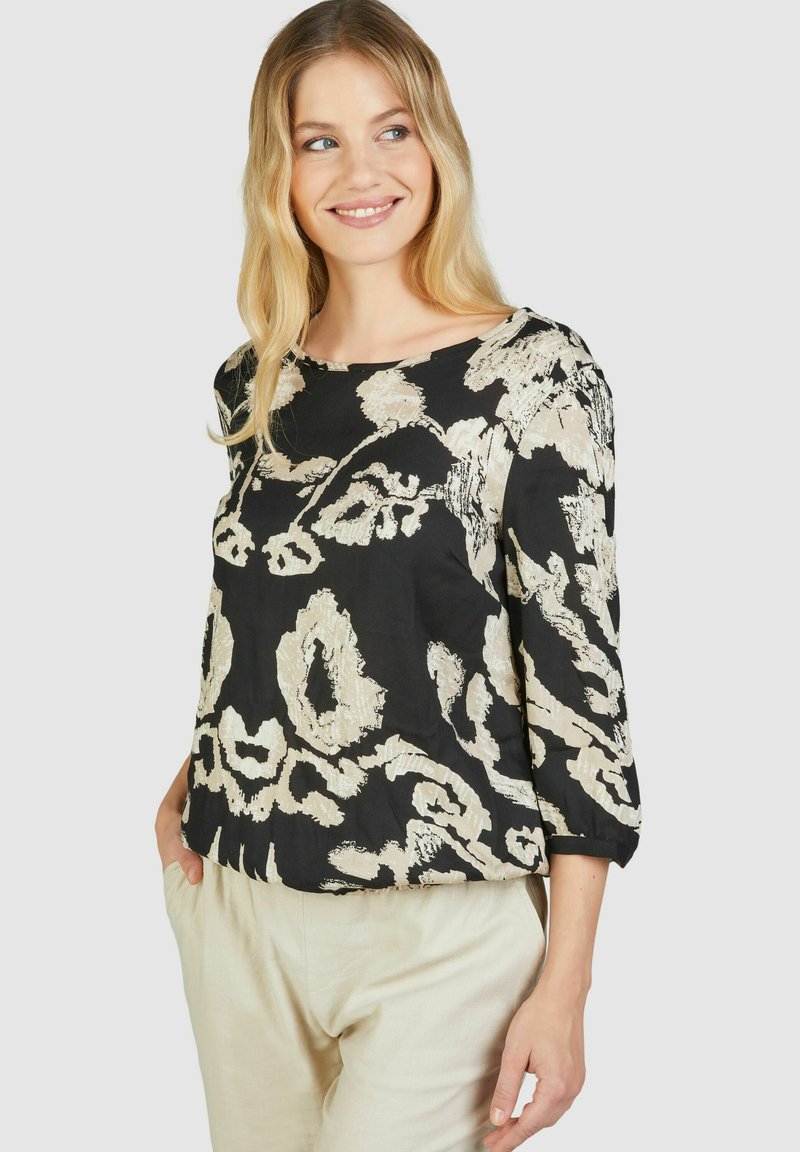 Schwarze Bluse mit beigem abstractem Muster, runder Ausschnitt, dreiviertel Ärmel, leichtes Material und leicht lockere Passform.