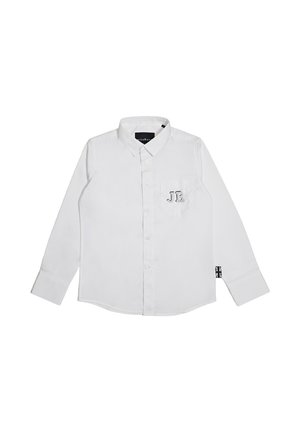 Camicia bianca a maniche lunghe con bottoni, colletto, tasca sul petto con la scritta "Jr." e una piccola etichetta Union Jack sulla cucitura laterale.