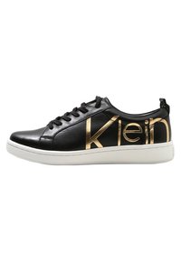 Černé kožené nízké tenisky s černými tkaničkami, bílou podrážkou a velkým zlatým logo "klein" na boku.