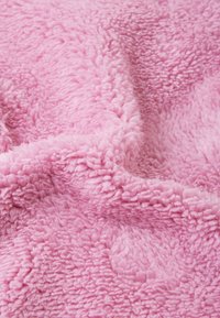 Pink plush blanket with soft, fluffy texture, showcasing a textured surface and a smooth, warm appearance. Lightweight and cozy design.