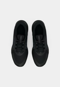 Sorte treningssko med teksturert overdel, kontrastdetaljer, snøring og et polstret såle, med en strømlinjeformet design.