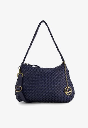 Gewebte Handtasche aus marineblauem Leder mit einem geflochtenen Tragegurt, Reißverschluss und goldfarbenen Beschlägen. Akzentuiert mit einem Anhänger, der ein kreisförmiges Friedenssymbol zeigt.