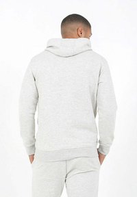 Sudadera con capucha gris en tela suave. Presenta mangas largas y un bolsillo frontal. Diseño sencillo con puños y dobladillo acanalados. Vista trasera mostrada.