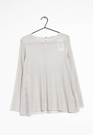 Longsleeve w jasnoszarym kolorze, z pionowym prążkowanym wzorem, okrągłym dekoltem oraz małym zapięciem na suwak z tyłu.