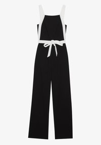 Černý overal s širokými nohavicemi, bílými ramínky a uvázaným páskem v pase. Disponuje jednoduchým designem a hladkou texturou látky.