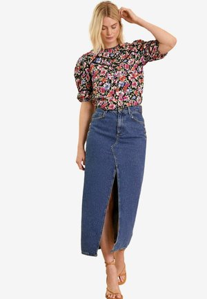 Blusa floreale a maniche corte con maniche a sbuffo abbinata a una gonna in denim a vita alta, lunga fino al ginocchio, con uno spacco frontale e dettagli a bottoni.