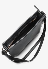 Black leather handbag with a zipper closure, slim design, and adjustable strap. Interior features a soft lining and golden zipper details.