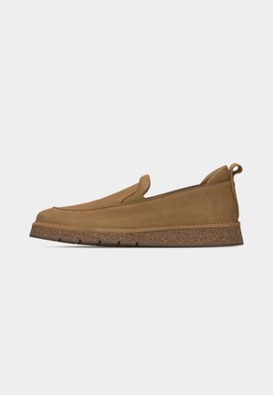 Tan suede slip-on shoe with textured brown sole, elastic side panels, and pull tab at the heel, shown in profile on a white background.