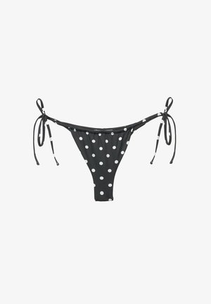 Sort bikini bund med hvide prikker, der har justerbare sidebånd og et minimal dækning design. Glat stoftekstur.