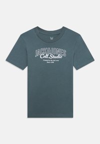 Tirkizna pamučna majica s kratkim rukavima i okruglim izrezom. Sadrži bijeli tiskani tekst: "JACK & JONES Coll. Studio" i logo. Redoviti kroj.