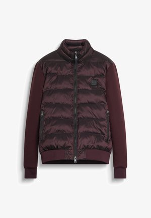 Maroon puffer jacket with a high collar, zip closure, and side pockets. Features contrasting fabric and a branded tag on the chest.
