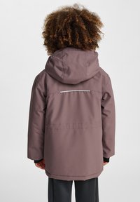 Lila Kapuzenjacke mit einer glatten, matten Oberfläche; verfügt über einen reflektierenden Streifen auf dem Rücken und elastische Bündchen für eine enge Passform.