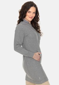 Felpa lunga con cappuccio grigia realizzata in materiale morbido, con maniche lunghe, tasche laterali e orlo curvo. Design semplice senza motivi visibili.