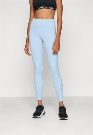 Leggings atletici azzurro chiaro realizzati in materiale elastico, con una vita alta e una texture liscia. Abbinati a scarpe da corsa nere.