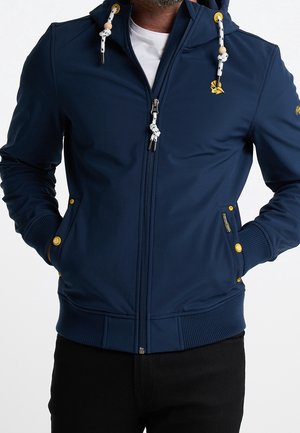 Felpa con zip di colore blu navy realizzata in tessuto morbido, con lacci bianchi decorati con perline, due tasche frontali con bottoni gialli e polsini a coste.