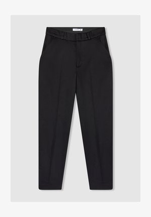Pantaloni neri con finitura liscia e opaca, gambe affusolate, tasche laterali e vita aderente con passanti per la cintura.