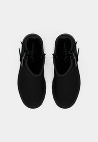 Μαύρα μποτάκια αστραγάλου κατασκευασμένα από λείο υλικό με στρογγυλεμένο σχήμα. Διαθέτουν φερμουάρ μπροστά και λεπτές κορδονένιες διακοσμήσεις σε κάθε πλευρά.