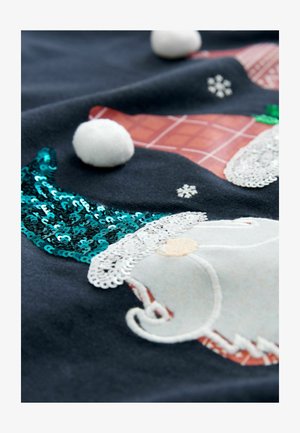 Čierna látka s vyšívaným trpaslíkom s bielou bradou, tyrkysovým flitrovým klobúkom a bielymi brmbolcami. Detaily textúry a vzorov sú prítomné.