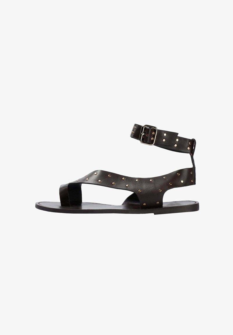 Sandales en cuir noir avec une bride de cheville, dotées de clous dorés sur le dessus et d'un design ouvert à l'avant. Semelle plate avec un minimum de rembourrage.