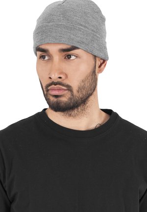 Gray ribbed beanie hat made of knitted fabric. Features a snug fit and simple design. Worn with a black crewneck shirt.