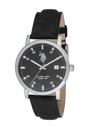 Montre ronde argentée avec cadran noir, repères d'heure blancs et aiguilles blanches, affichage de la date, logo U.S. Polo Assn. et bracelet en cuir noir.