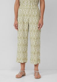 Jasnozielone krótkie spodnie z białym wzorem liści, elastyczny pas i luźny krój. W połączeniu ze srebrnymi sandałami na paski.
