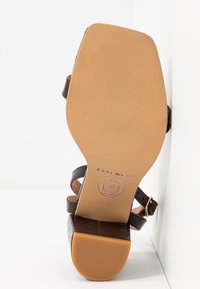 Sandale marron à brides avec bout carré et talon bloc, vue de la semelle texturée marquée "Pavement" et taille 37.