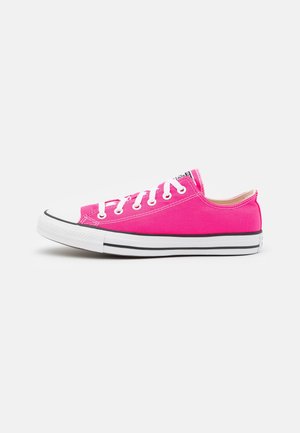 Sneakers in tela rosa con lacci bianchi, punta in gomma e strisce nere sulla suola. Design basso con silhouette classica.