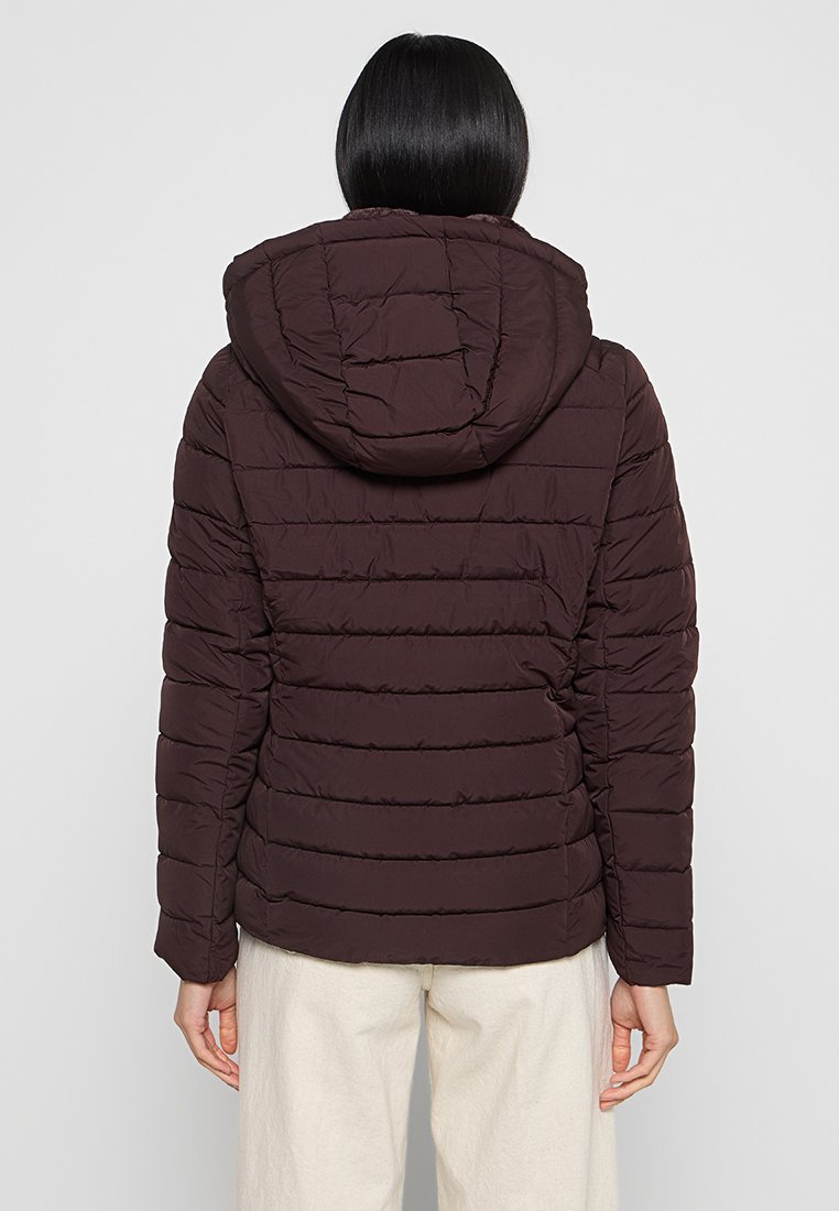 Doudoune marron avec capuche, présentant un design matelassé et des coutures horizontales. Le matériau semble doux et rembourré. Vue arrière montrée.