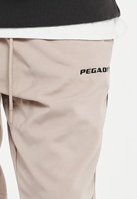 Pegador LOGO PANTS UNISEX - Joggebukse - taupe/black
