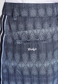 Czarne szorty z kropkowanym wzorem przechodzącym od jasnego do ciemnego, z teksturowanej tkaniny, elastycznym pasem i bocznymi paskami.