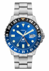 Montre Fossil avec un cadran bleu, un bracelet en acier inoxydable argenté, une lunette noire, des index d'heure blancs et une touche d'orange sur la trotteuse.