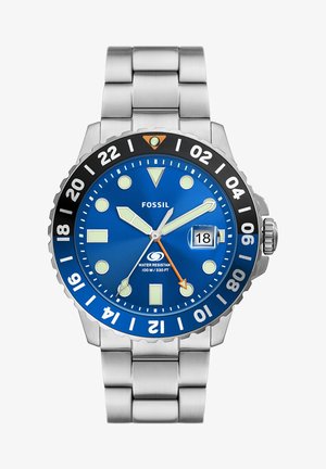 Montre Fossil avec un cadran bleu, un bracelet en acier inoxydable argenté, une lunette noire, des index d'heure blancs et une touche d'orange sur la trotteuse.