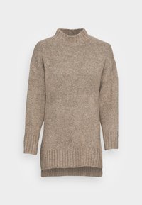 Beige Strickpullover mit hohem Kragen, langen Ärmeln und einem gerippten Saum. Der Stoff hat ein texturiertes, leicht flauschiges Aussehen.