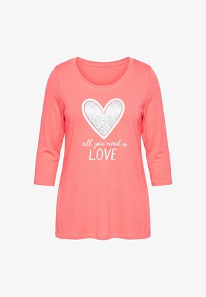 Korálově růžová košile s dlouhým rukávem se stříbrným srdcem a bílým textem "Vše, co potřebujete, je LÁSKA" na přední straně, s kulatým výstřihem.