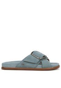 Infradito in suede blu chiaro con una cinturino largo, accentato da una fibbia argentata e una suola piatta marrone, caratterizzato da una parte superiore testurizzata e design aperto sulla punta.