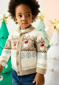 Kremo spalvos megztas kardiganas su rudais akcentais, puošnus siuvinėjimais su elniais ir sniego seniu, su šalikiniu apykaklės dizainu ir mygtukų užsegimu.