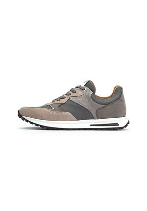Zapatilla gris y beige con parte superior de ante, detalles de malla y una entresuela blanca. Presenta cordones y una suela de goma negra.
