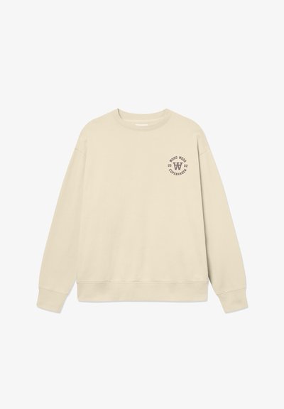 Sweatshirt beige en coton. Présente un col rond, des manches longues et un petit logo graphique sur la poitrine gauche. Texture lisse.
