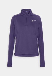 Lila långärmad Nike-pullover med kvartdragkedja och vit swoosh-logga på vänster bröst, tumhål på ärmsluten, enfärgad bakgrund.