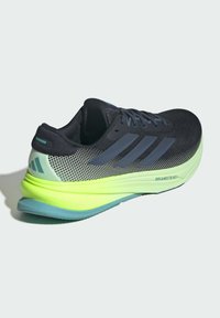 Schwarzer und grüner Sportschuhe mit einem Obermaterial aus Mesh, das mit dunkelblauen Akzenten und einer lebhaften neongrünen Sohle versehen ist, gekennzeichnet mit "DREAMSTRIKE".